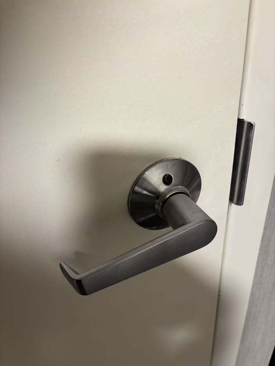 A metal door handle for an interior room door.