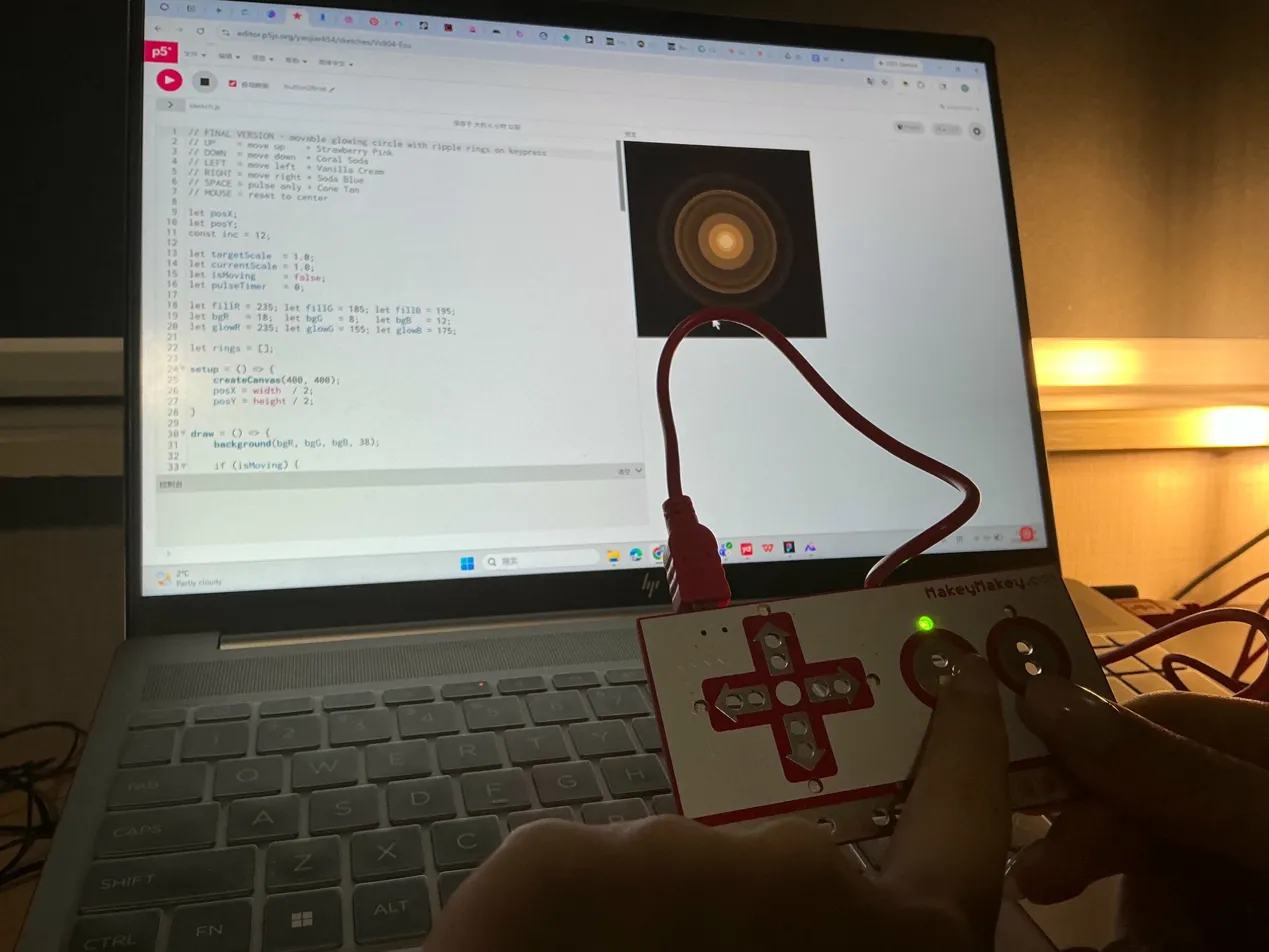 Laptop shows a dark canvas with warm golden concentric ripple rings expanding outward, Makey Makey in hand.