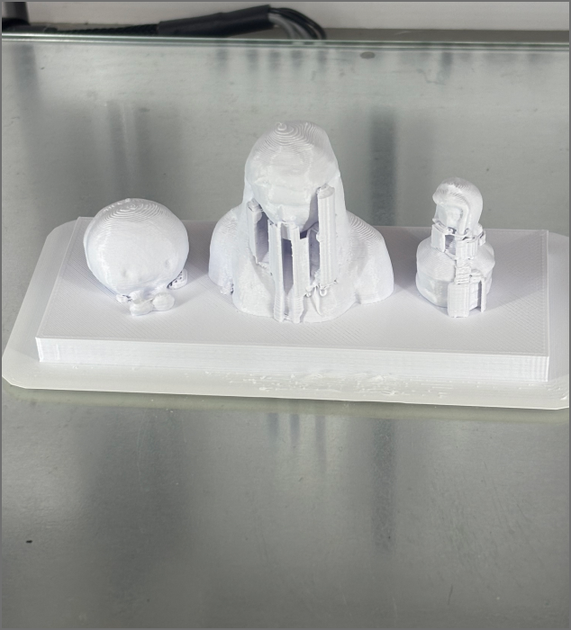 The image shows the completed 3D-printed models with attached support structures awaiting cleanup.